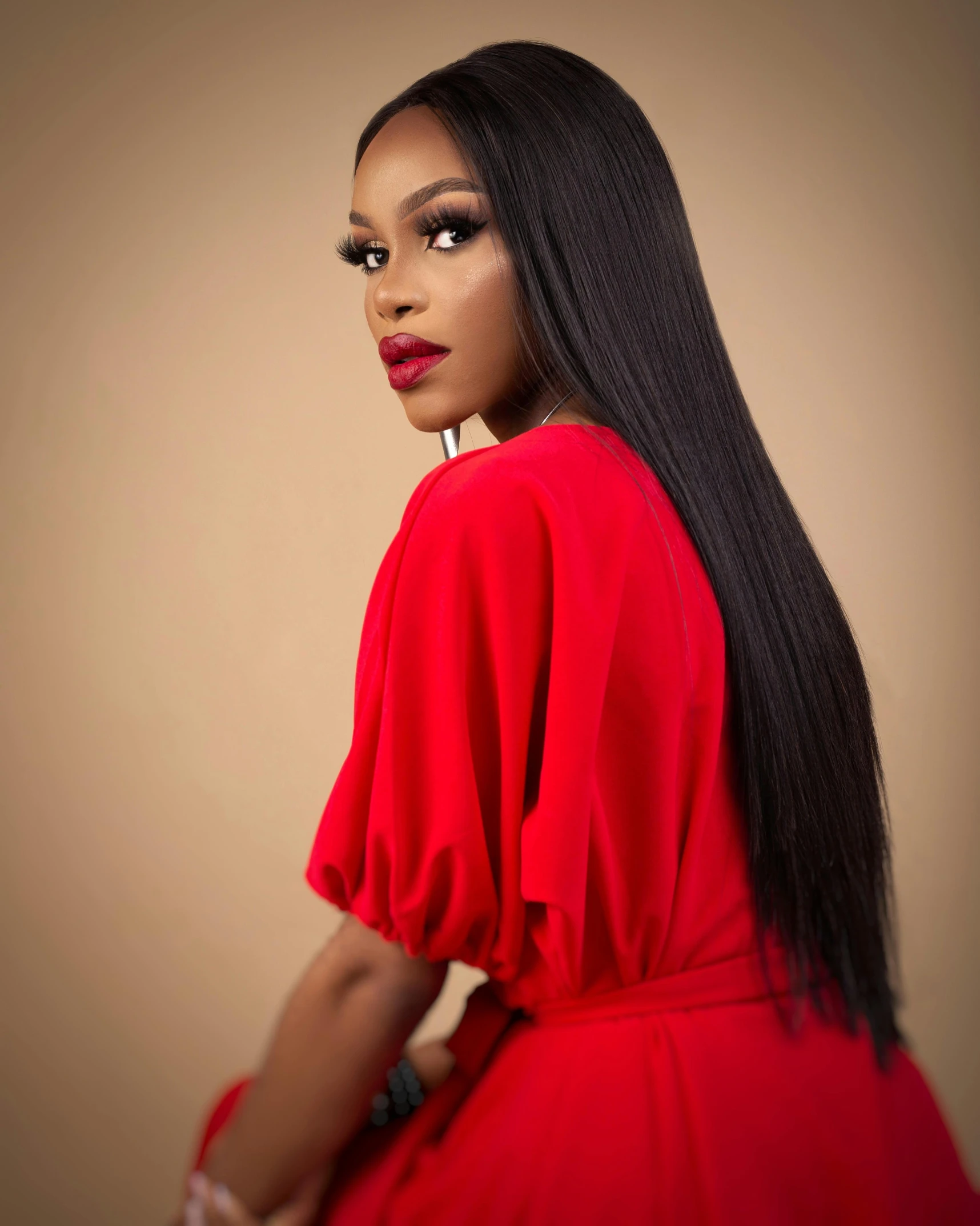 an african american girl in a red dress wearing a black hoop earrings