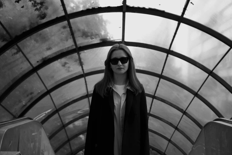 a girl is standing in the middle of an empty subway