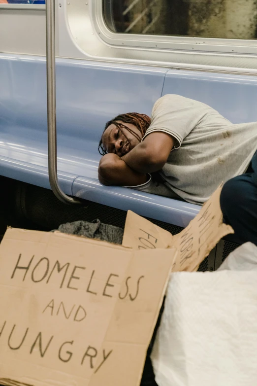 a homeless man sleeping on a subway train