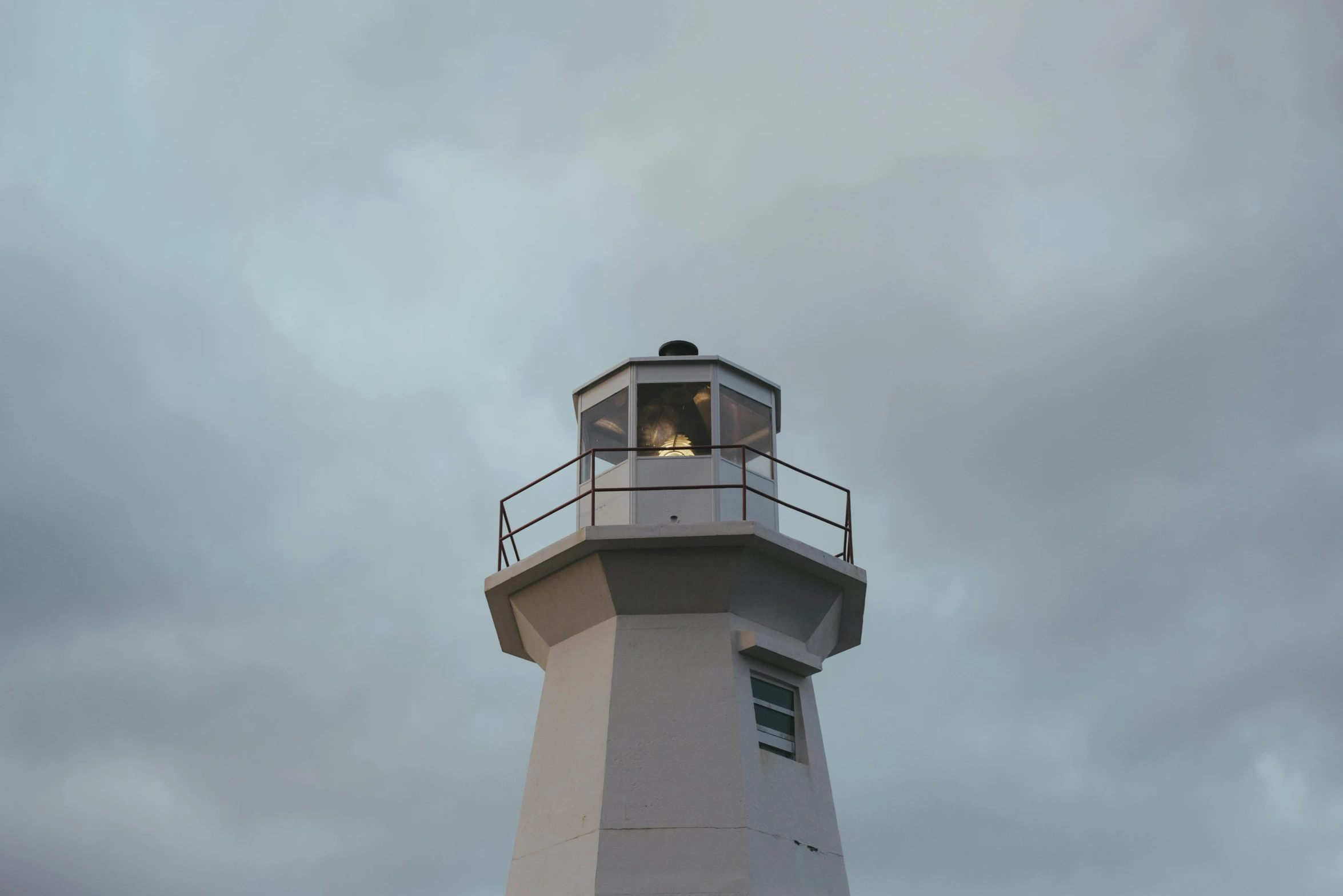 a light house with a grey background and some clouds