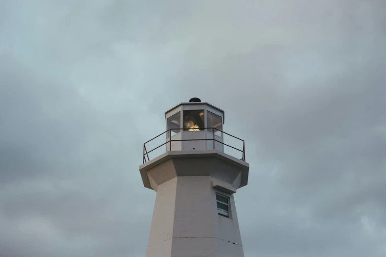 a light house with a grey background and some clouds