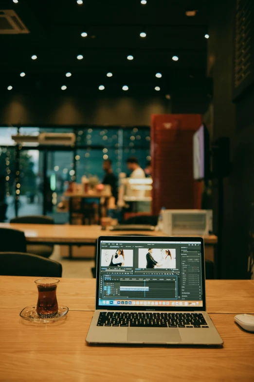 a laptop sits on the table in front of some glasses