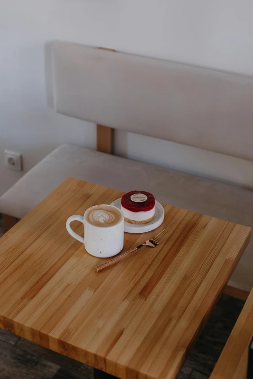 coffee cup and saucer on small wooden table in small room