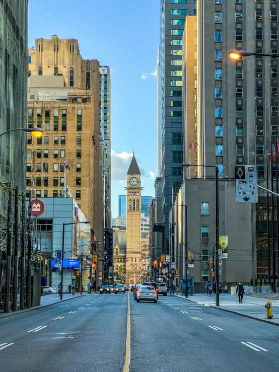 a city street with a very tall clock tower in the distance