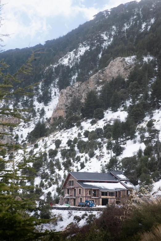 a snow covered mountain side cabin with a building on the bottom