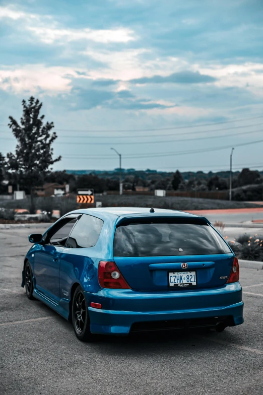 a blue hatchback car parked in a parking lot