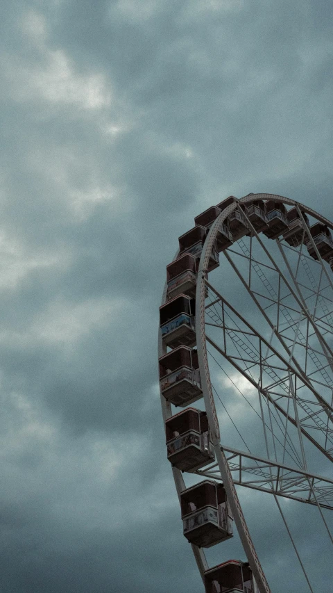 a large metal ferris wheel against a cloudy sky