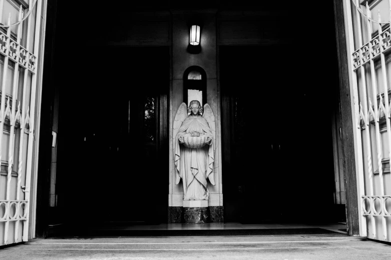 a statue in a building doorway with the lights on