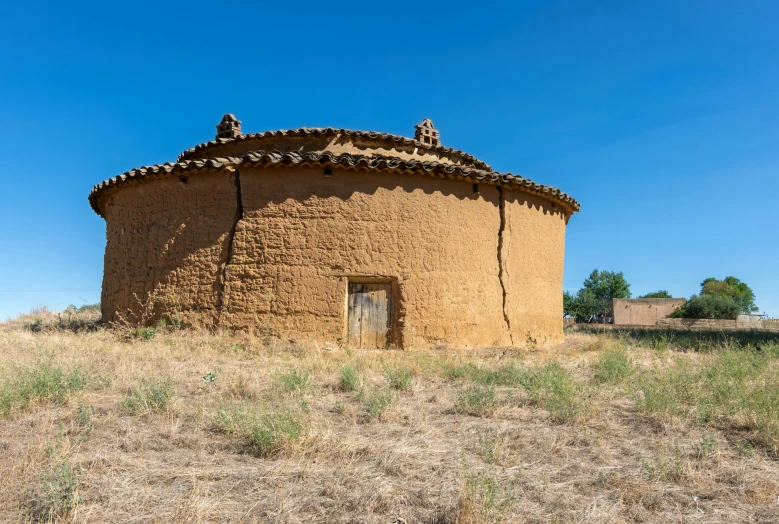 an adobe house with two chimneys and a door