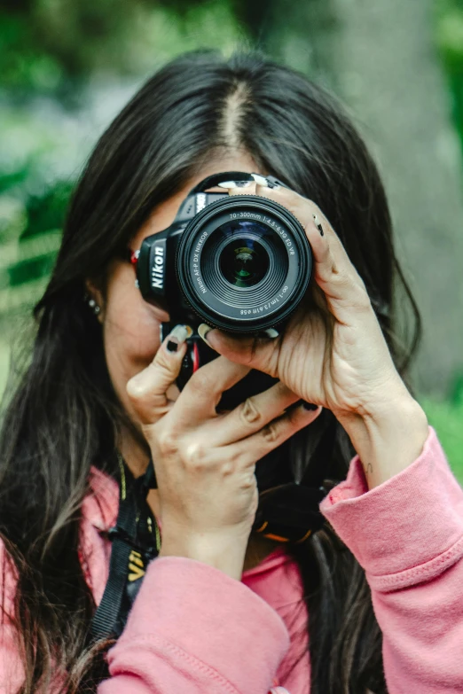 a woman wearing pink taking a po with a digital camera