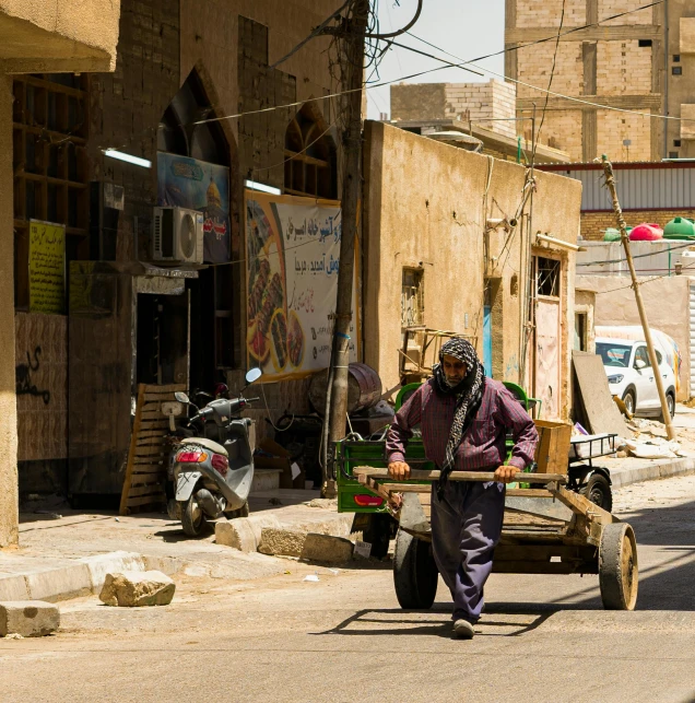 a woman carrying a cart with a motorbike on the back