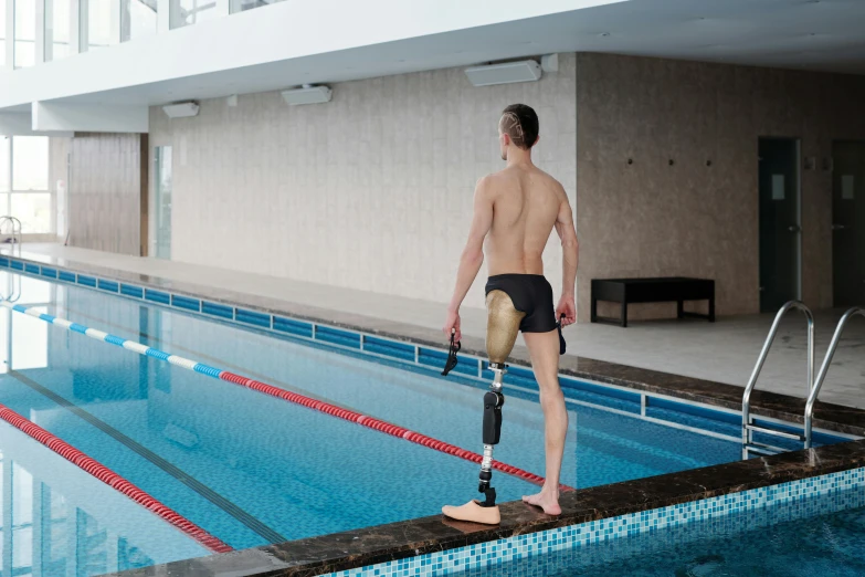 a man with a leg ce standing near an empty pool