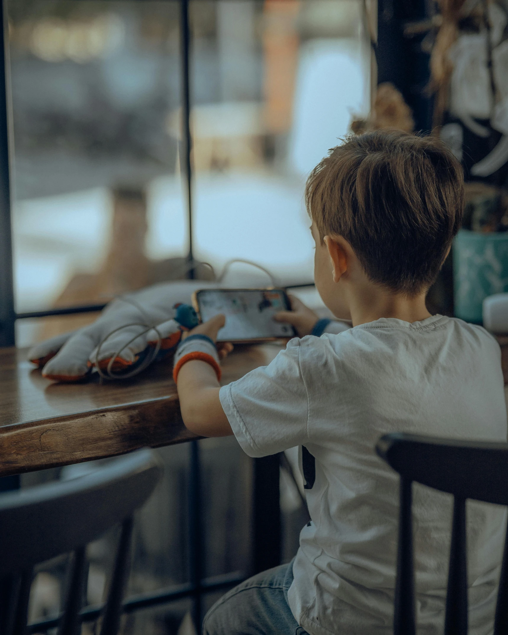 a child in a white shirt is sitting at a table