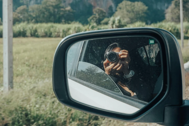 a man taking a po through his car mirror