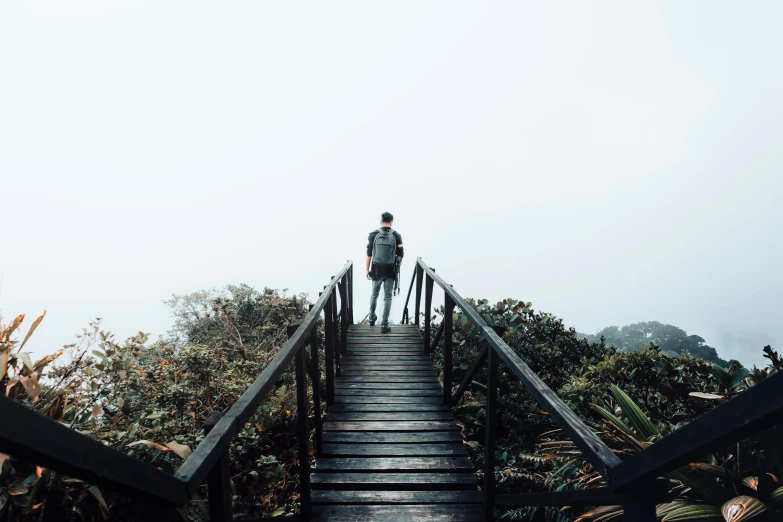 a man standing on top of a wooden stair case