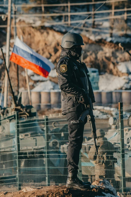 a person standing at the edge of a bridge wearing a jacket and holding an army knife