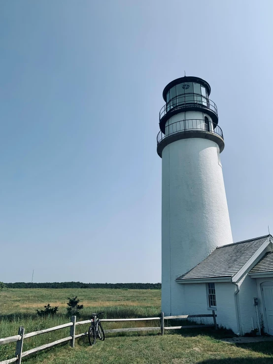 an old lighthouse stands in front of the farm