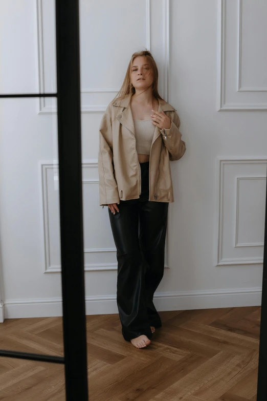 a woman posing in front of a white wall