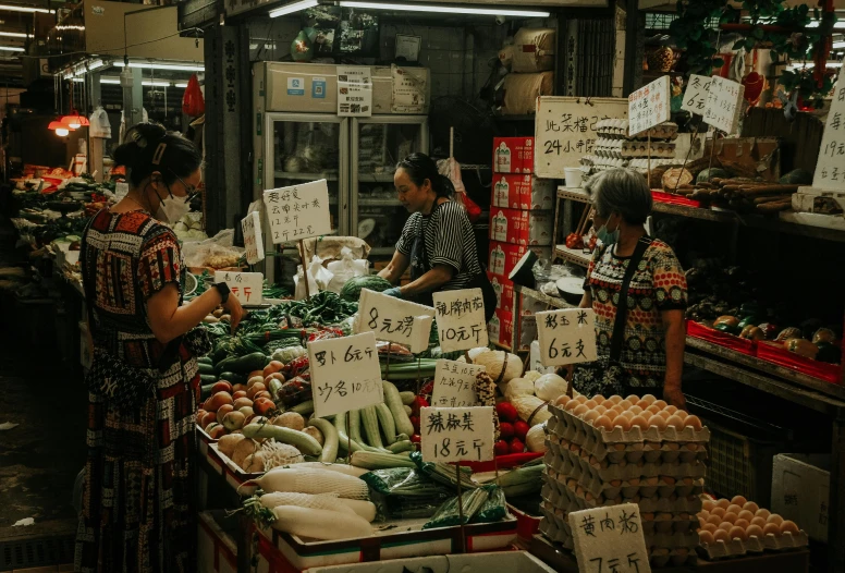 women are shopping at the produce stand for sale