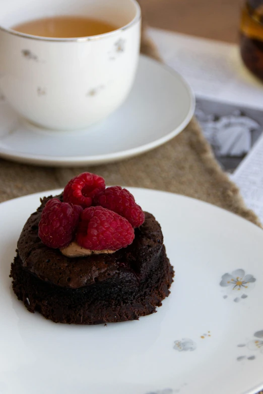 the small cake has been placed on the plate next to a cup