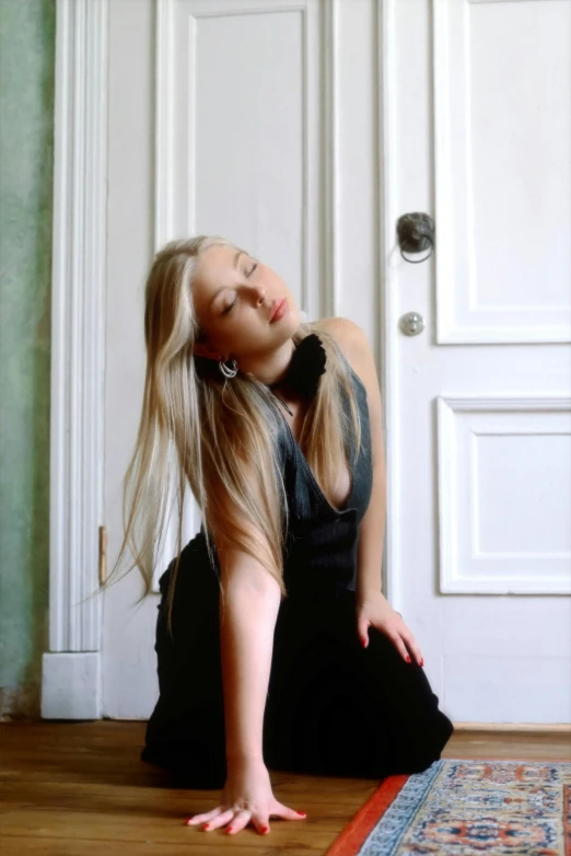 a girl kneeling on the floor in a room with white door