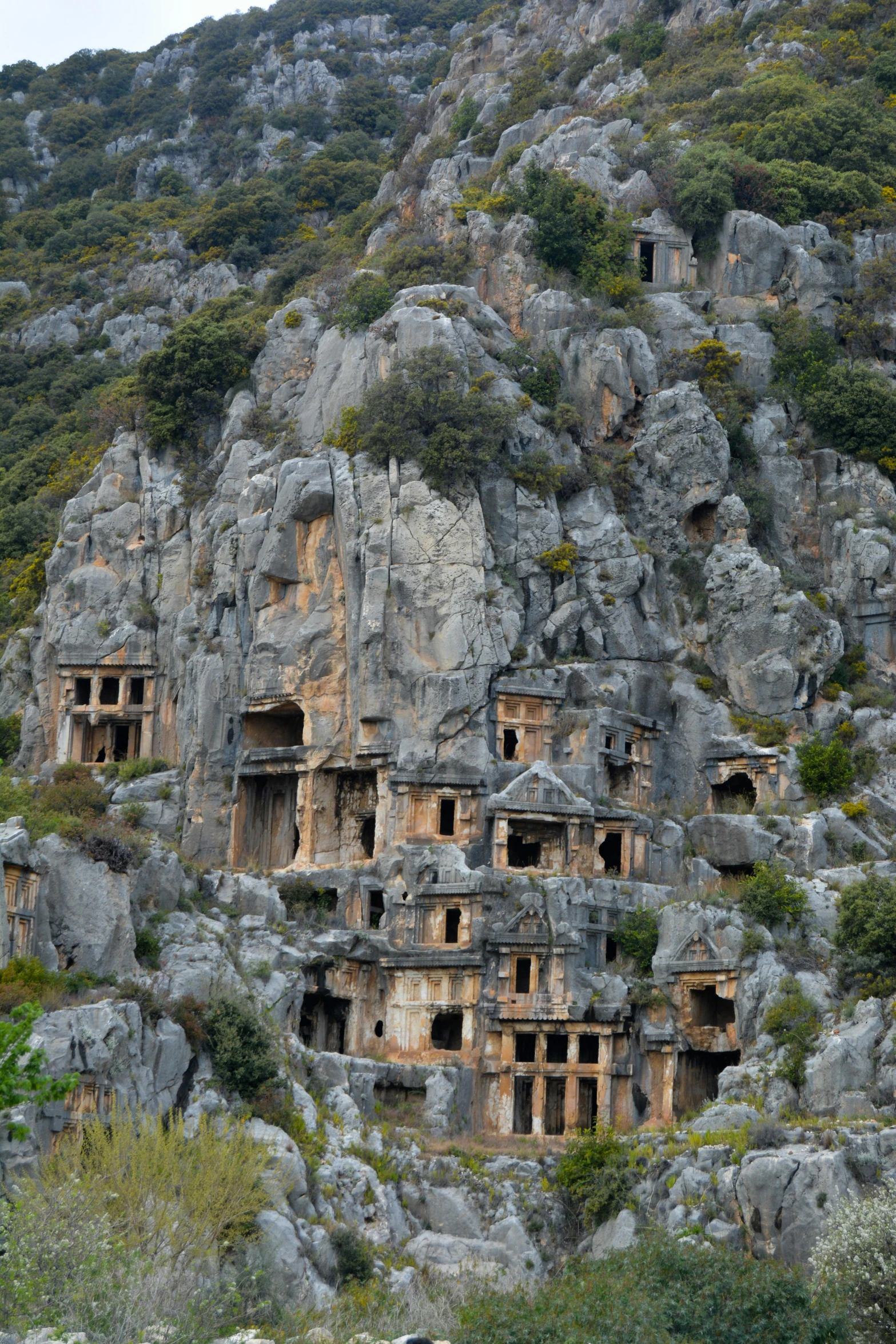 several rocks on a hill with several caves