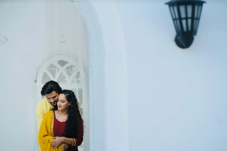 a man and woman emce in front of a white door