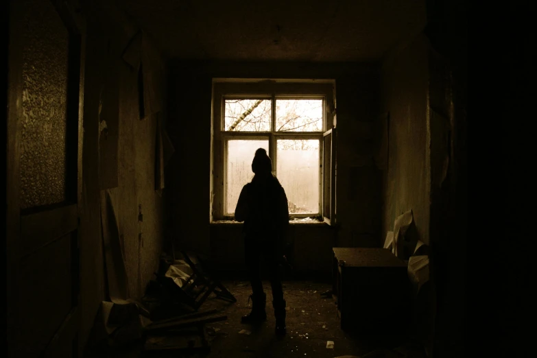 a person standing in the dark near a window