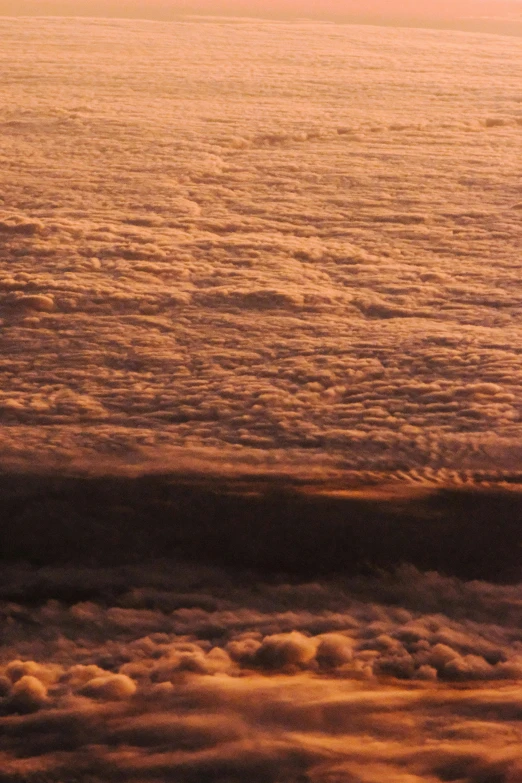 an ocean filled with lots of clouds covered in brown and blue