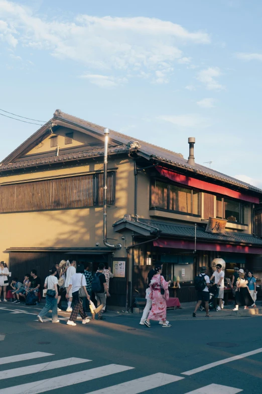 people crossing in the street in front of a building