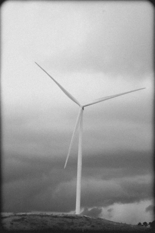 two wind mills and cloudy skies in the distance