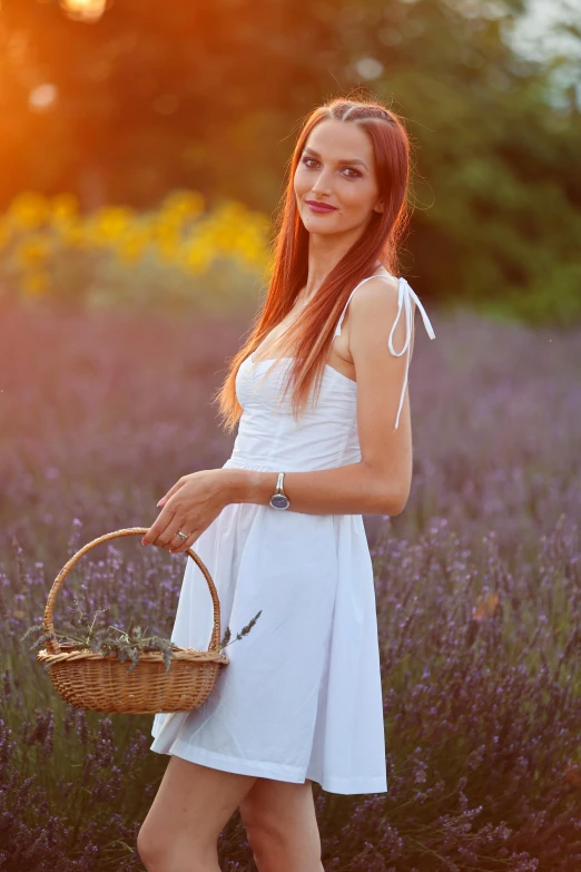 a pretty young woman holding a basket in a field