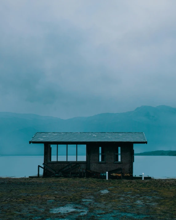 an abandoned shack in front of a large body of water