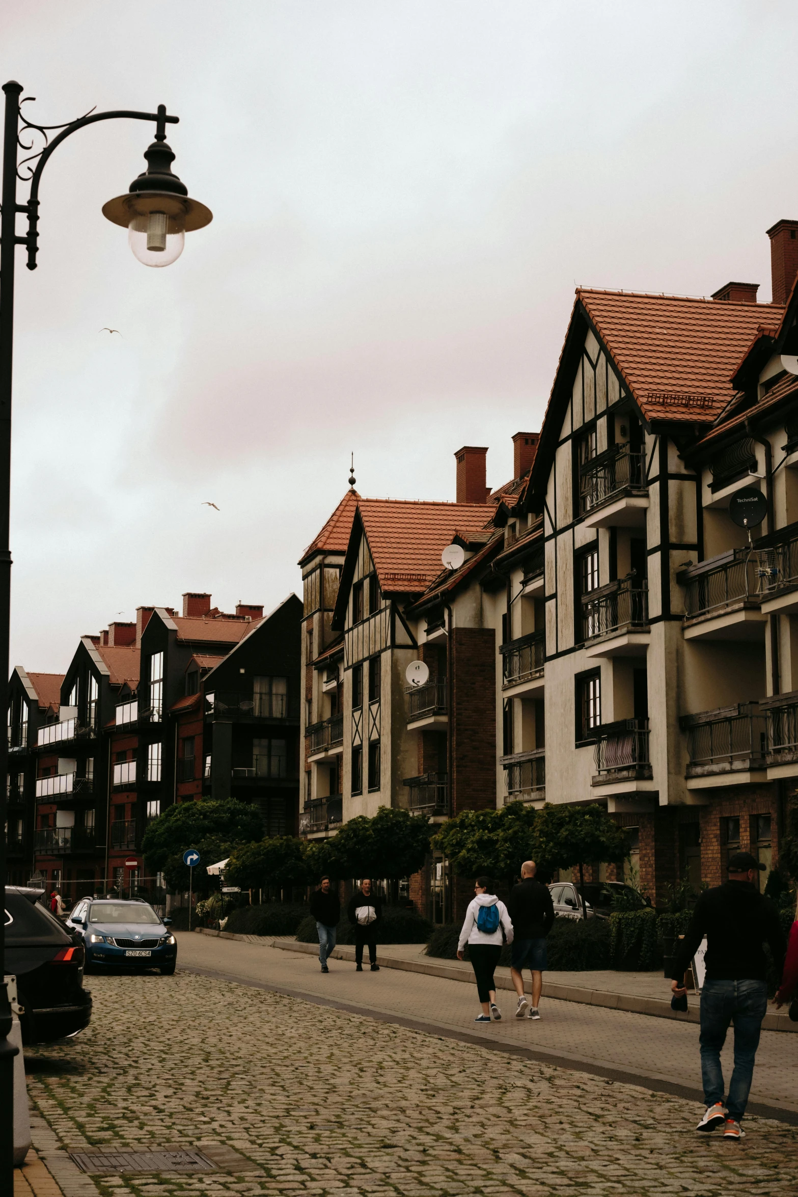 a street scene with a few people walking and cars