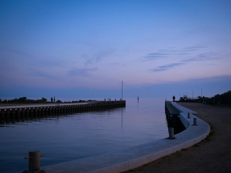 a long body of water with a large long pier on the side of it