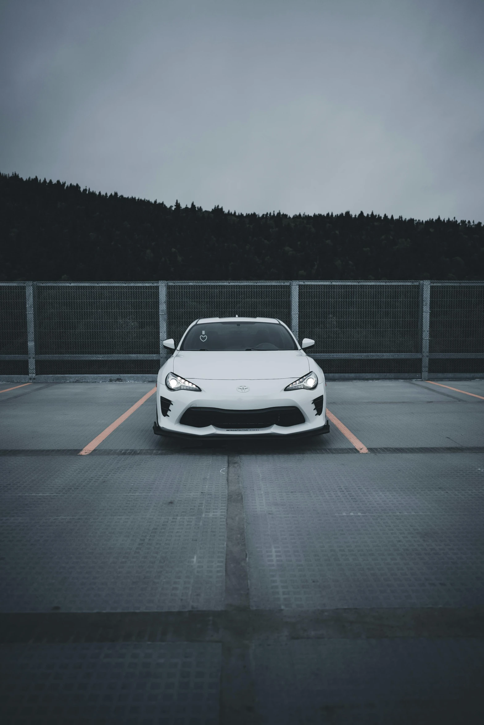 a white sports car parked in a parking lot