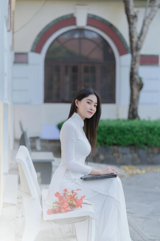 woman in white dress sitting on a bench outside