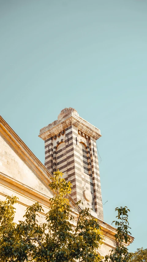 a building has a tall tower and trees outside