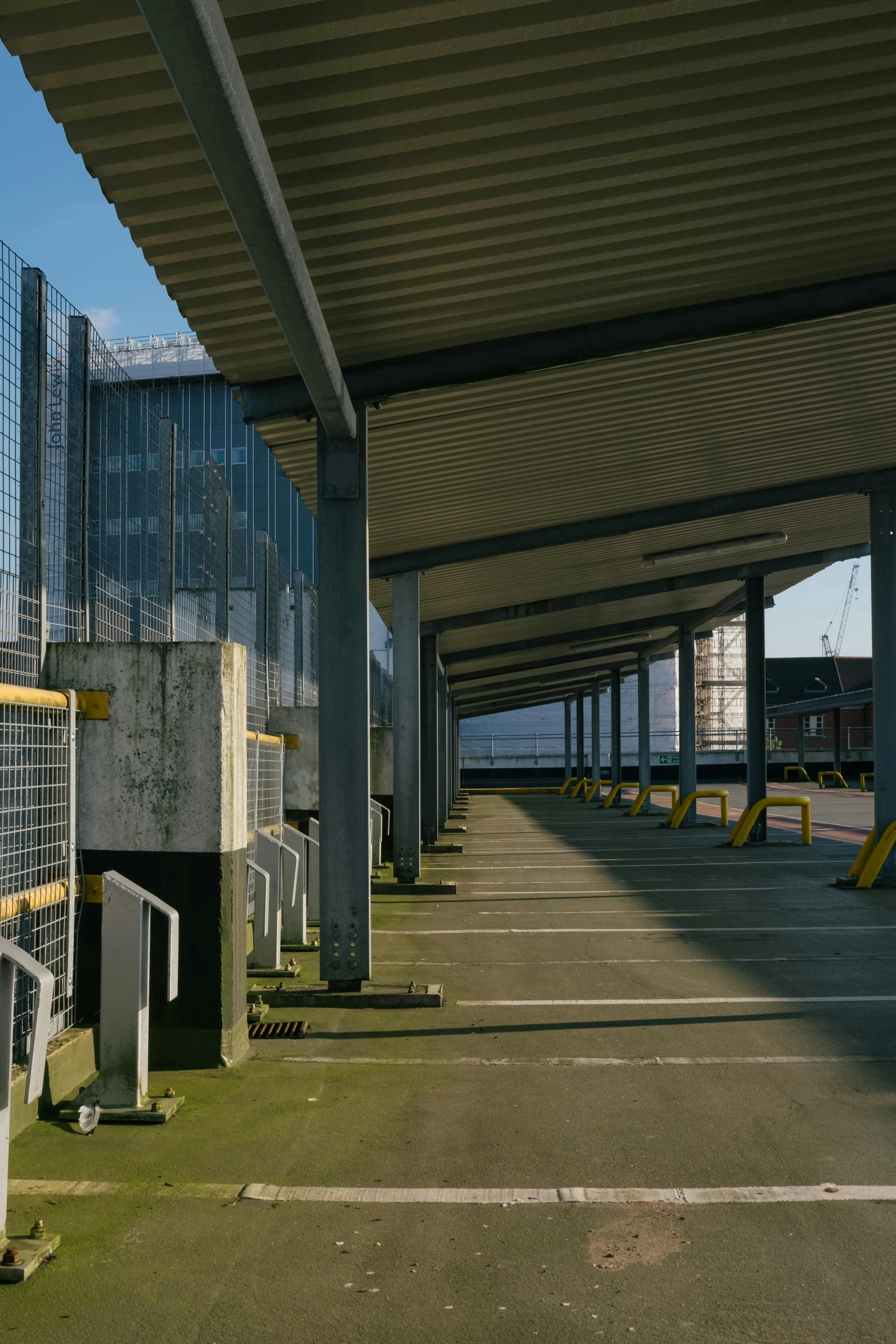 a car park filled with parking space under a bridge