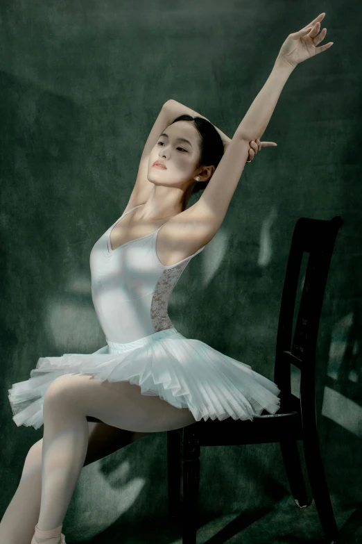 a young woman wearing a white ballet costume is posing on a chair