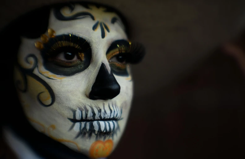 a woman wearing black with white face paint