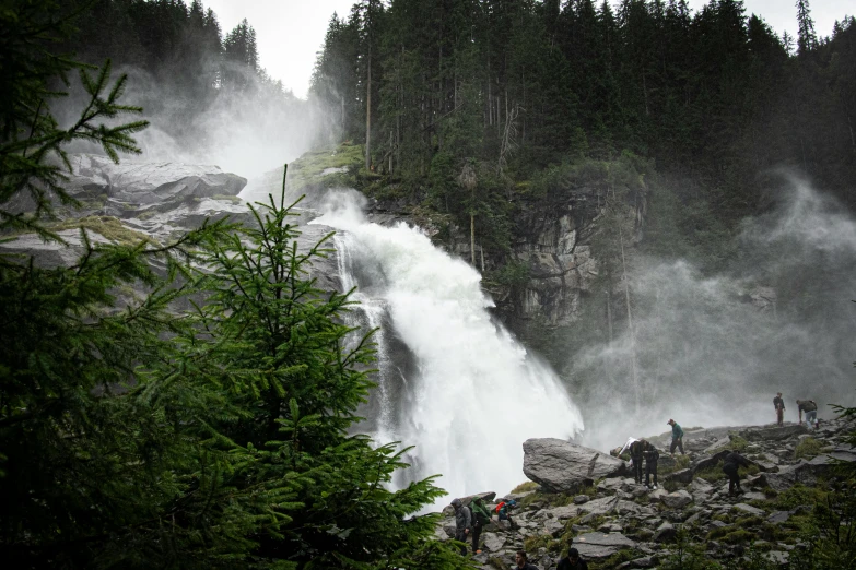 a group of people walking next to a waterfall