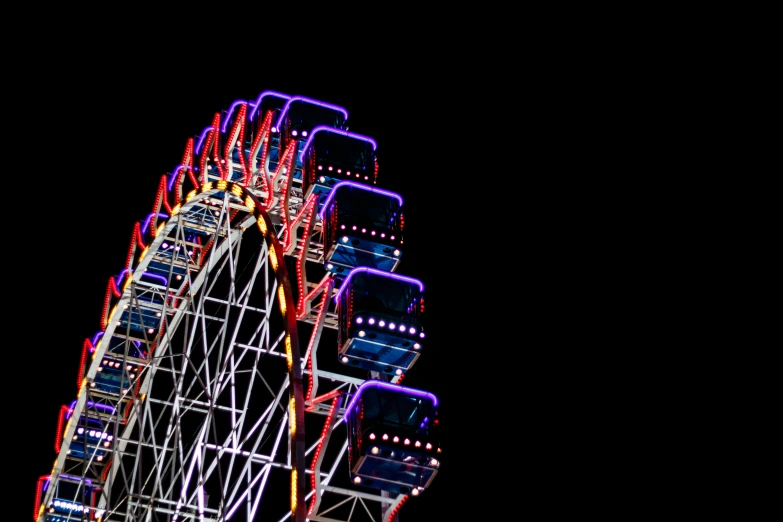 a very big brightly lit ferris wheel at night