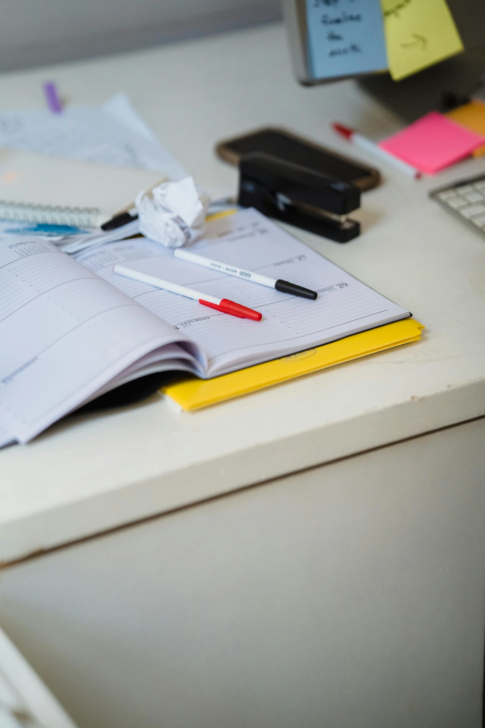 a pen, paper, and calculator are displayed on a desk