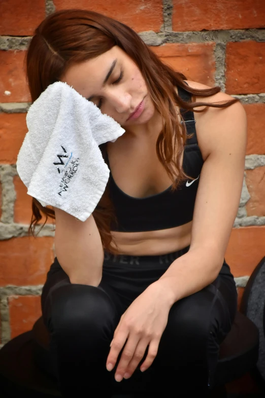 a girl holding a towel and sitting on the floor