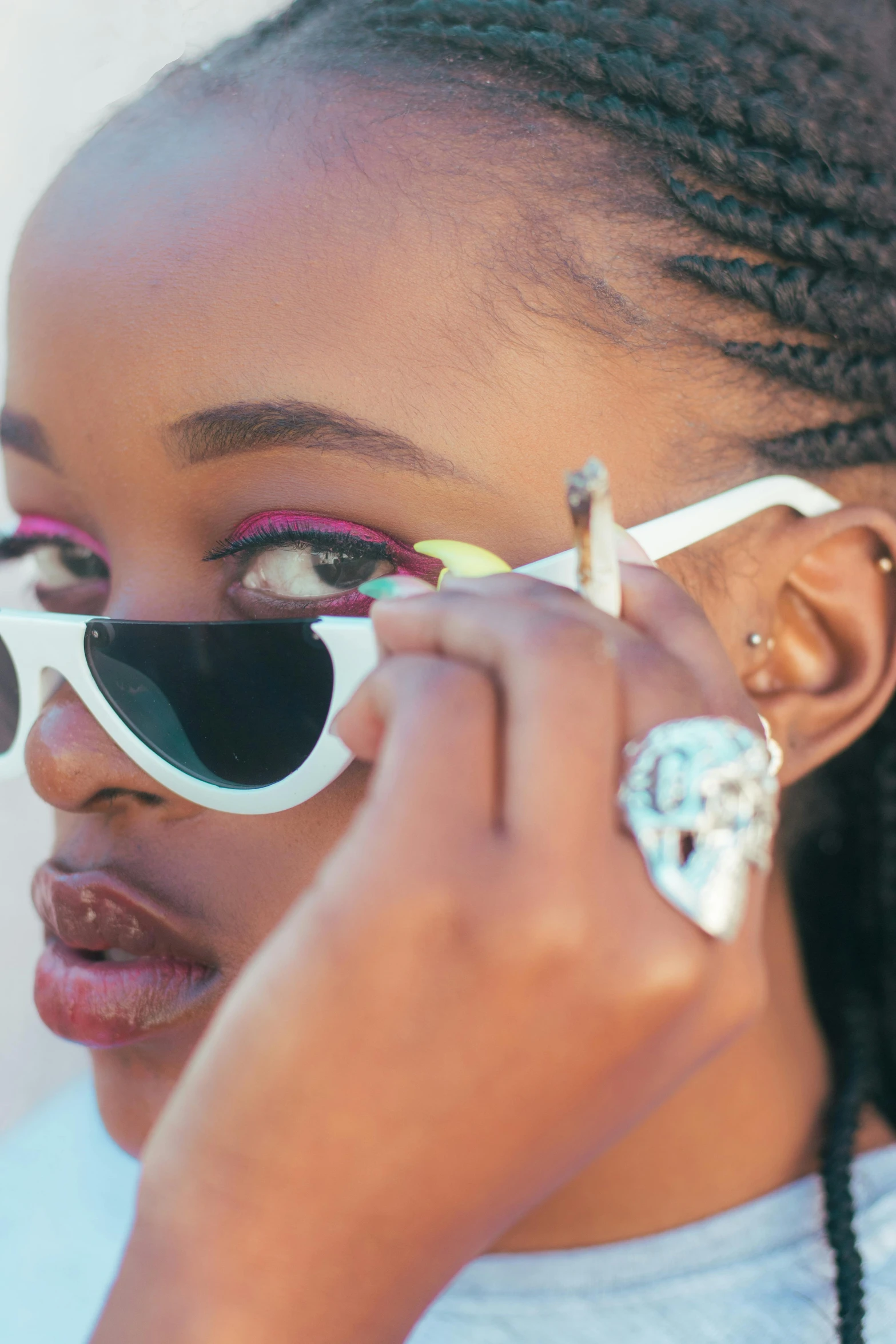 a woman with large sunglasses adjusting her sunglasses