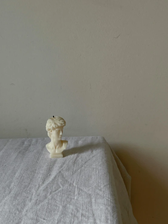 a toy figurine sitting on top of a bed