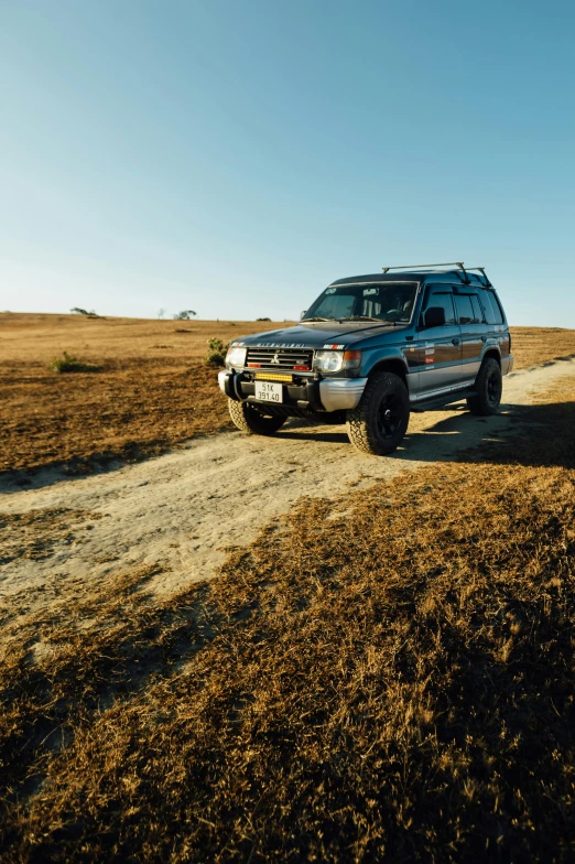 a police suv is driving on the dirt road