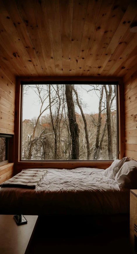 a bed that has pillows on top of it in a room with a window