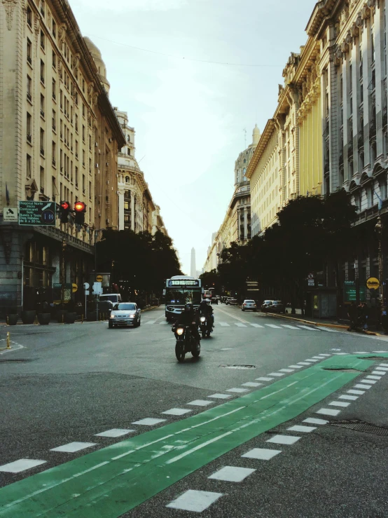 some cars are driving down a street near the traffic lights